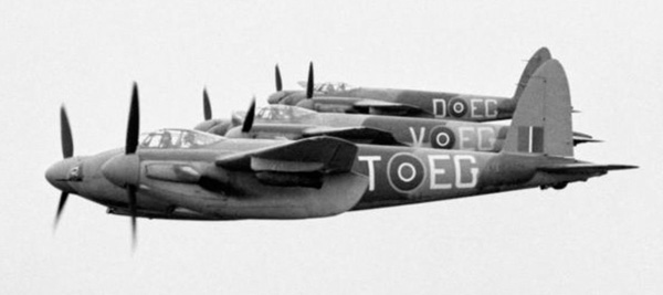 Tre Mosquito FB Mark VI fra nr. 487 Squadron RNZAF basert på Hunsdon, Hertfordshire, flyr i tett styrbord sjiktformasjon, med 500-lb MC-bomber på undervingeskip
