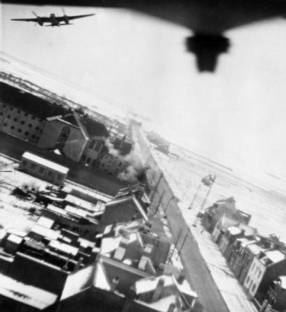 Muggen van No. 487 Squadron RNZAF ontruimen het doel op lage hoogte terwijl de eerste 500-pond bommen die worden gedropt ontploffen nabij de zuidelijke muur van de gevangenis